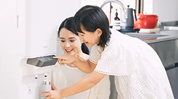 ウォーターサーバーから水筒に水を注ぐ親子