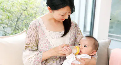 赤ちゃんにミルクをあげる女性